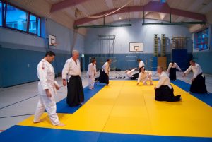 Trainingsgruppe auf der Matte in der Turnhalle